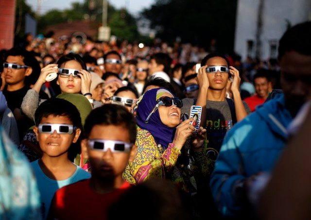 EAGER CROWD. Indonesian residents wearing eclipse glasses look up at the sun during a solar eclipse outside the planetarium in Jakarta, Indonesia, March 9, 2016. Mast Irham/EPA 