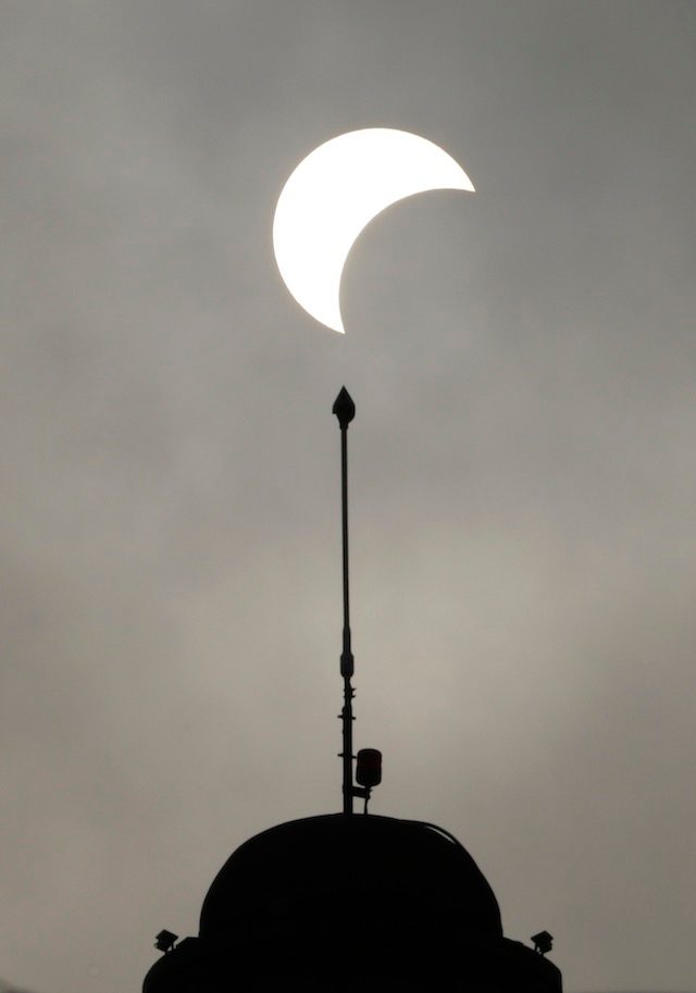 CAMBODIANS' VIEW. A partial solar eclipse is seen on the Independence monument in Phnom Penh, Cambodia, March 9, 2016. MAK REMISSA/EPA 