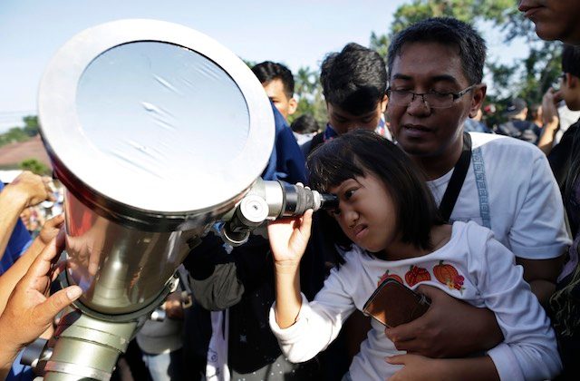 THROUGH THE TELESCOPE. An Indonesian young girl looks up at the sun through a telescope during a solar eclipse outside the planetarium in Jakarta, Indonesia, March 9, 2016. Mast Irham/EPA 