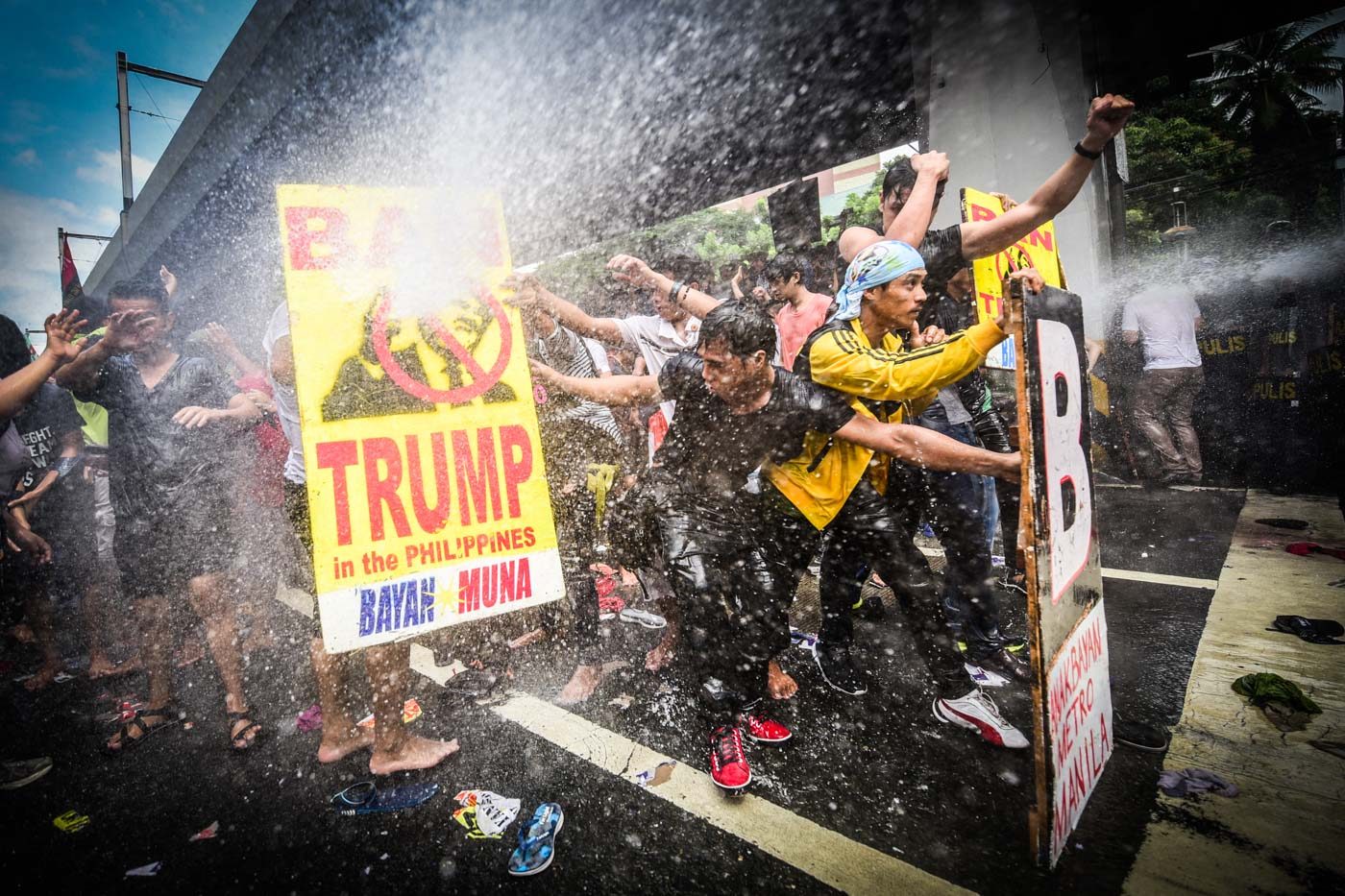 STANDING GROUND. #BanTrump activists hold their position as anti-riot police use water cannon and sonic alarm against them along the corner of Padre Faura and Taft Avenue, on November 13, 2017, to keep them from getting near the ASEAN Summit venue. Photo by Alecs Ongcal/Rappler  