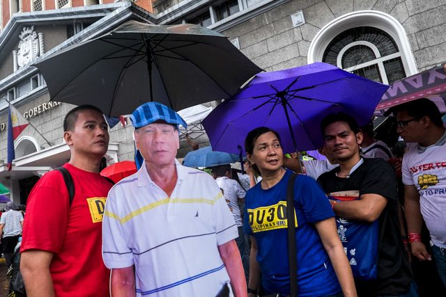 UNTIL THE END. Duterte's supporters are left out in the rain after Duterte's no-show on the last day of filing of certificates of candidacy. Photo by Pat Nabong/Rappler 