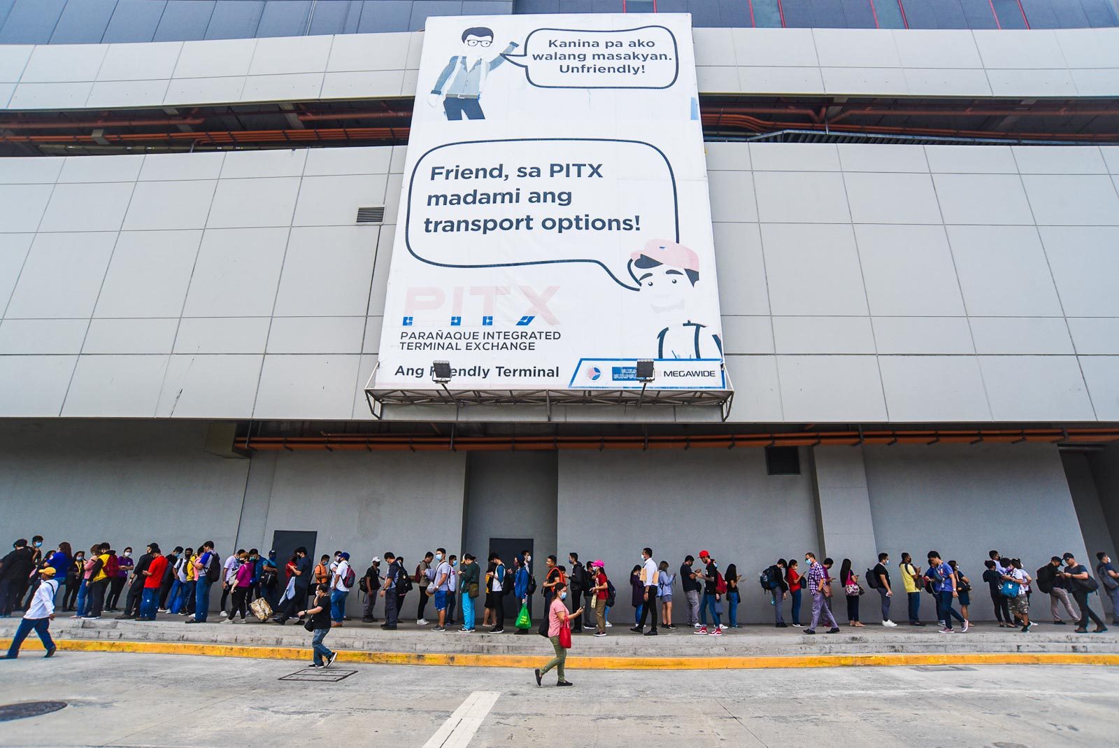LONG LINE. Commuters line up at the Paranaque Integrated Terminal Exchange for quarantine and identity check before they are allowed to take public transportation going in and out of Metro Manila on March 16, 2020. Photo by Angie de Silva/Rappler 
