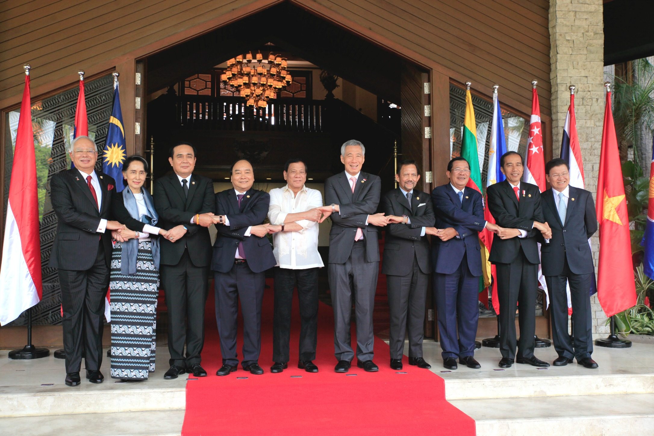 Malaysian Prime Minister Najib Razak (1st L), Myanmar State Counsellor Aung San Suu Kyi (2nd L), Thailand Prime Minister Prayuth Chan-o-cha (3rd L), Vietnamese Prime Minister Nguyen Xuan Phuc (4th L), Philippine President Rodrigo Duterte (5th L), Singapore Prime Minister Lee Hsien Loong (5th R), Sultan of Brunei Hassanal Bolkiah (4th R), Cambodian Prime Minister Hun Sen (3rd R), Indonesian President Joko Widodo (2nd R), Laos Prime Minister Thongloun Sisoulith (1st R) hold hands during the group photo of the 30th Association of Southeast Asian Nations (ASEAN) Summit at the Coconut Palace in Pasay City on Saturday, April 29, 2017. Pool Photo 