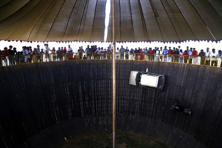 DARING STUNT. Indian people watch a 'Wall of Death' show at a fair in the outskirts of Ajmer, in the state of Rajasthan on August 11, 2018. Photo by Himanshu Sharma/AFP  