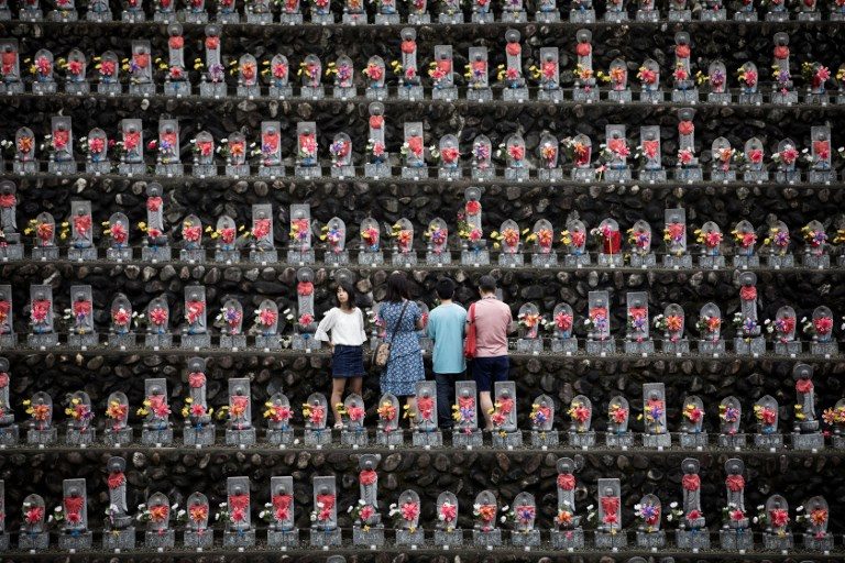 OBON PRAYERS PERIOD. A family pays respects in front of jizo statues in Jizoji Buddhist Temple in Oganomachi, Saitama prefecture, Japan, on August 13, 2018, for the souls of unborn children and those who died at a young age. Photo by Behrouz Mehri/AFP  