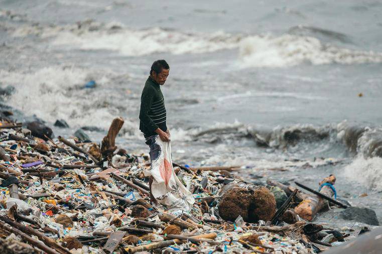SEA OF TRASH. A scavenger salvages for finds over heaps of garbage in Manila Bay on August 12, 2018, after a heavy downpour caused by the southwest monsoon. Photo by Greenpeace Philippines  