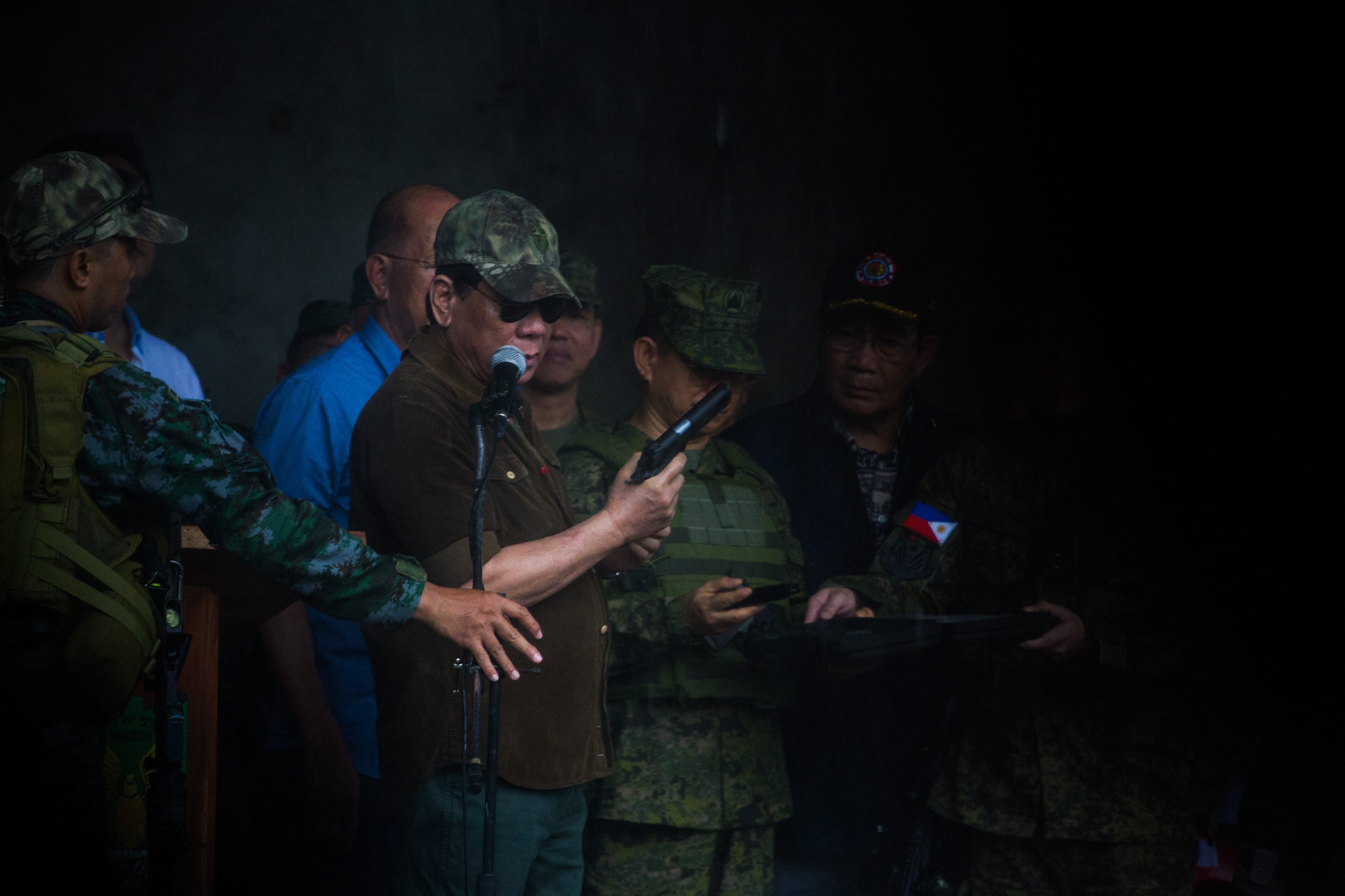 PISTOL. President Rodrigo Duterte shows a pistol he's going to give to the soldiers after declaring the liberation of Marawi City against the Maute terrorists on October 17, 2017. Photo by Bobbby Lagsa/Rappler  