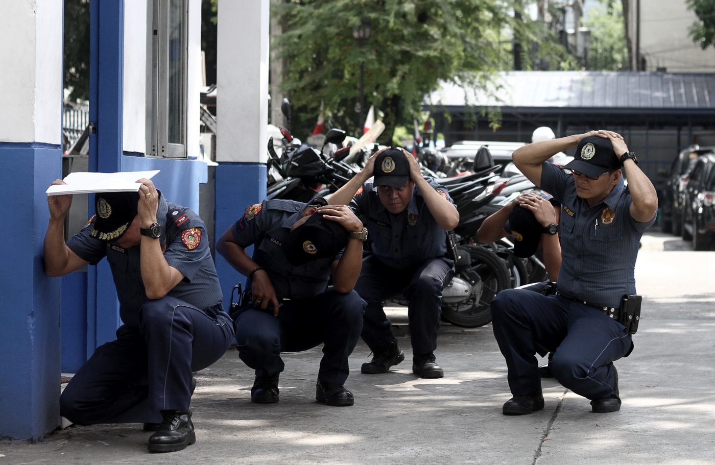 DUCK. Policemen at the Manila Police District headquarters take cover during the earthquake drill on June 29, 2017. Photo by Inoue Jaena/Rappler 