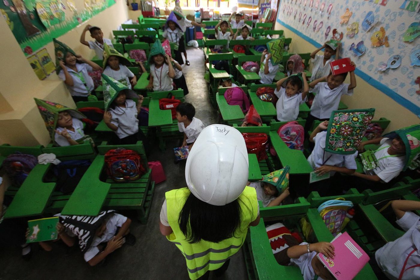 PRACTICE. Students of Corazon C. Aquino Elementary School in Batasan, Quezon City, cover their heads. Photo by Darren Langit/Rappler 