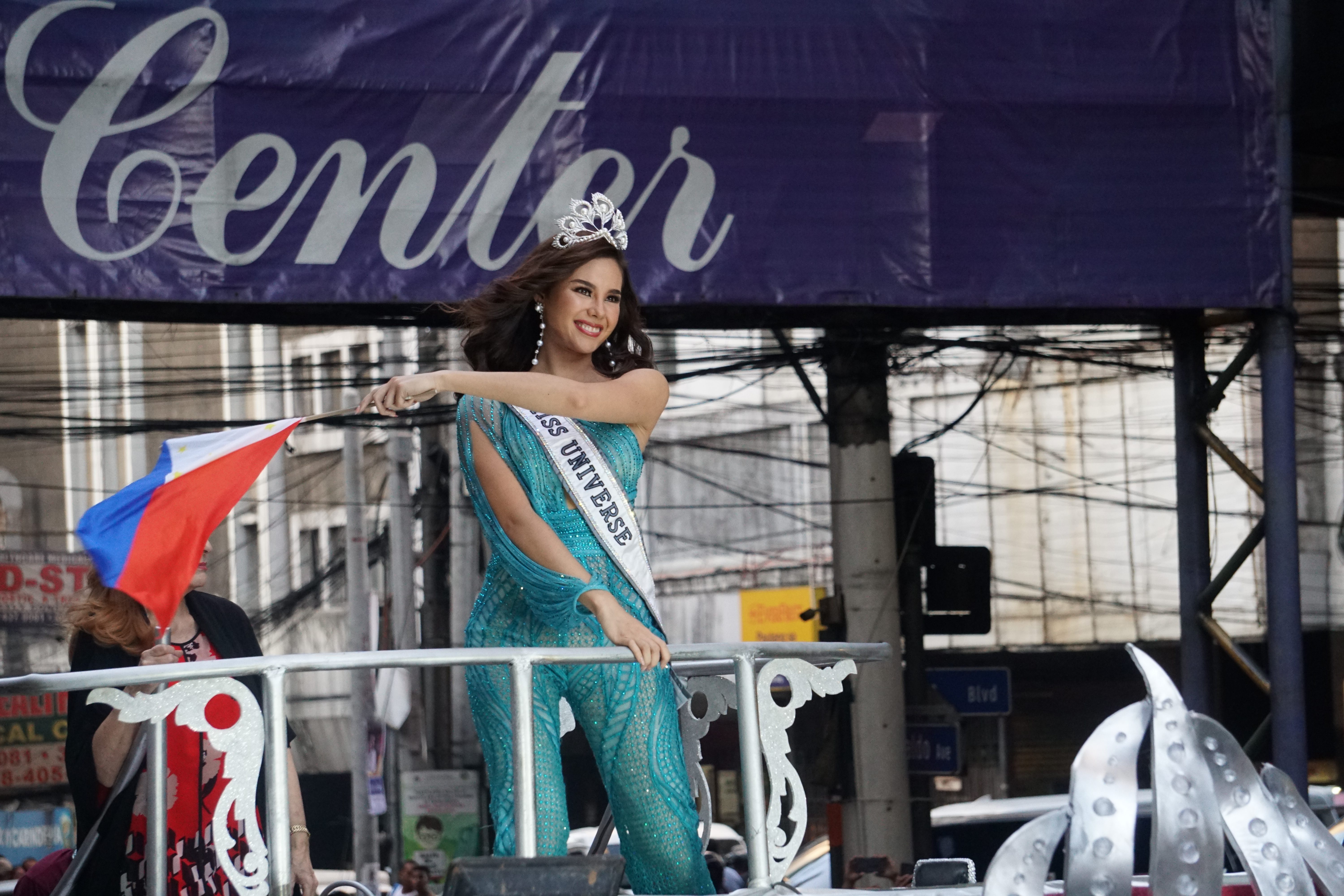 RAISE YOUR FLAG. Catriona Gray waves the Philippine flag during the motorcade. 