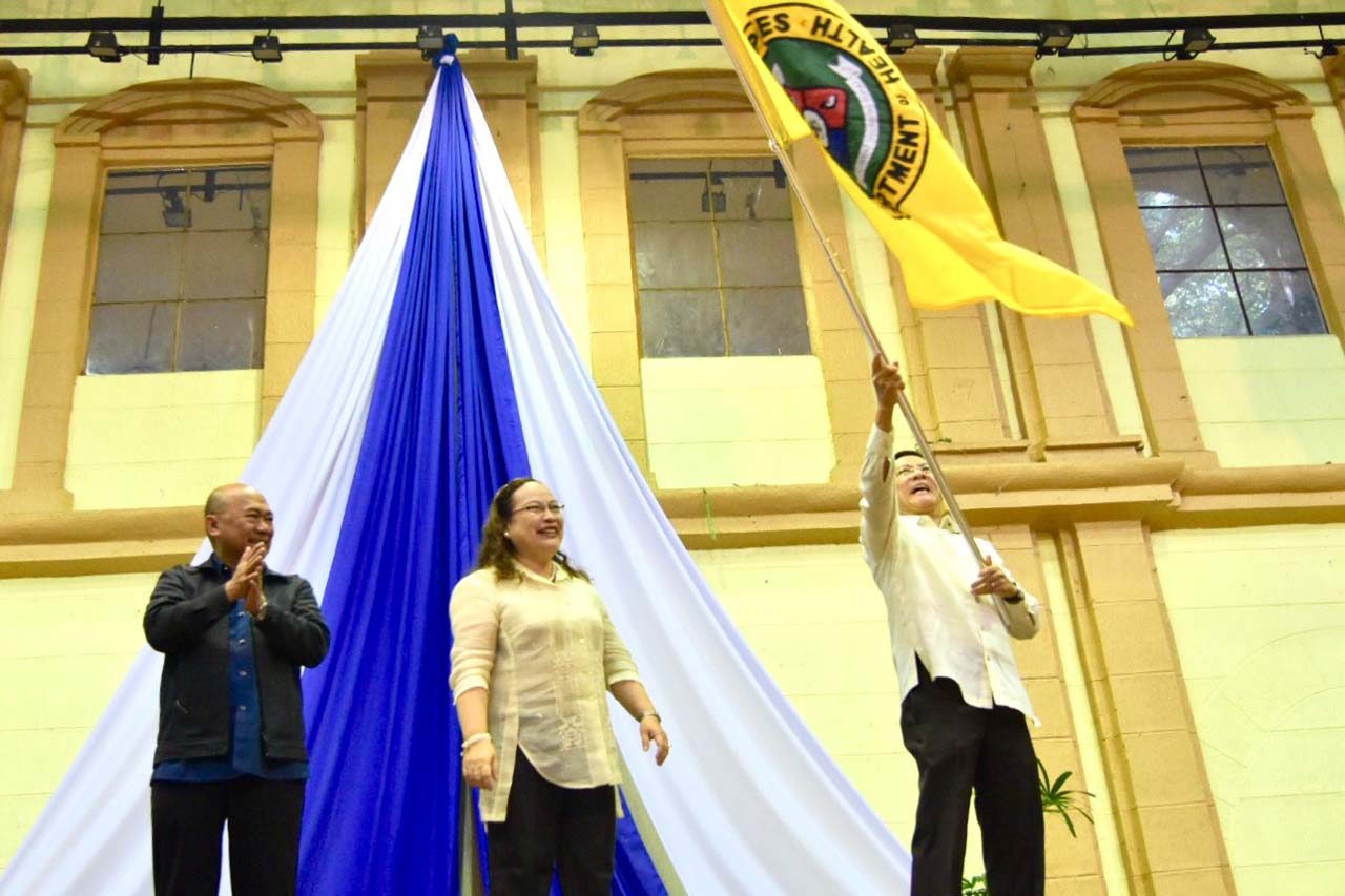 NEW CHIEF. Ubial looks on as Duque waves the DOH flag, signifying the change in leadership. Photo by LeAnne Jazul/Rappler 