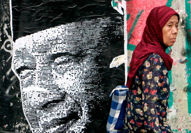Warga melewati poster mantan Presiden RI Soeharto di Jakarta. Foto oleh Mast Irham/EPA 