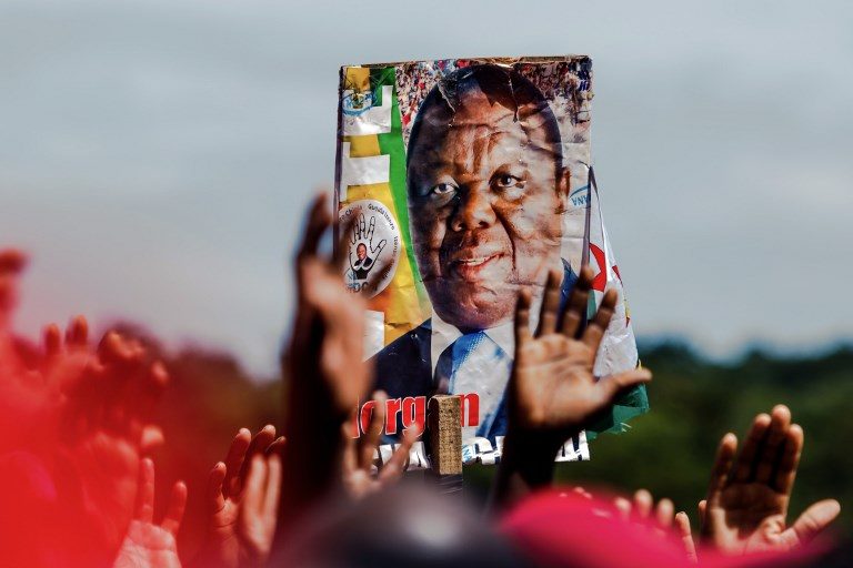 FAREWELL. Supporters of the Movement for Democratic Change (MDC) hold up a poster bearing a portrait of Zimbabwe's iconic opposition leader Morgan Tsvangirai who died  after a battle with cancer, during a memorial service on February 19, 2018, at Freedom Square in Harare. Photo by Jekesai Njikizana/AFP    