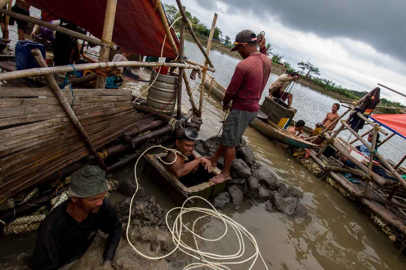 HEALTH HAZARD. A miner goes down to an underwater pit using a hose from a compressor as the only source of air.  Photo by Mark Saludes/Rappler