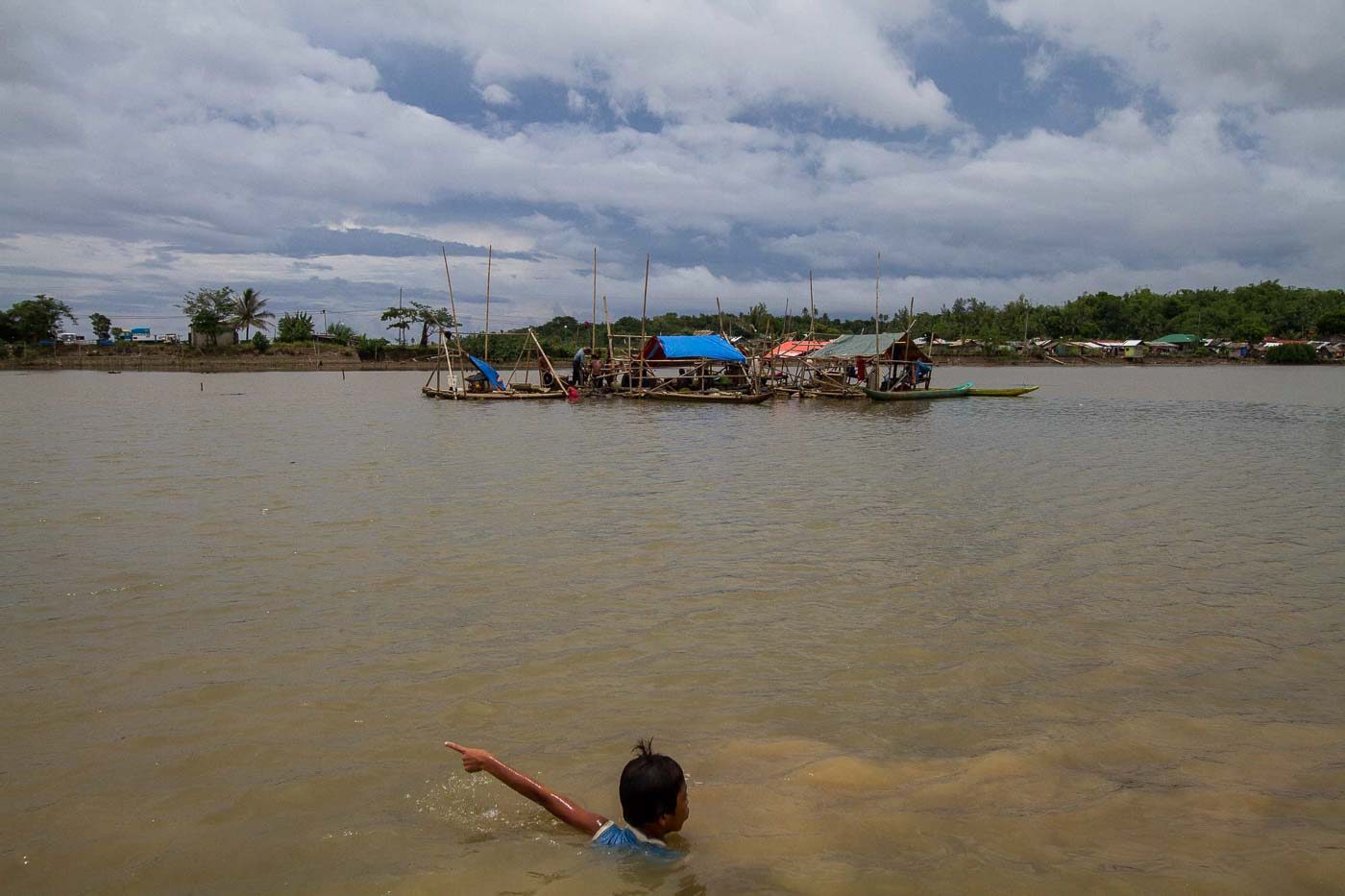 FOR THE FAMILY. A child swims in a swallow river bed to reach the next compressor mining site. Photo by Mark Saludes/Rappler   Photo by Mark Saludes/Rappler