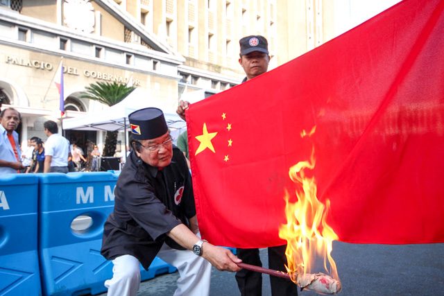 Ely Pamatong burns a Chinese flag in front of the Comelec office in Intramuros on Monday, October 12, during the first day of filing of certificates of candidacy for the 2016 elections. Photo by Joel Liporada/Rappler 