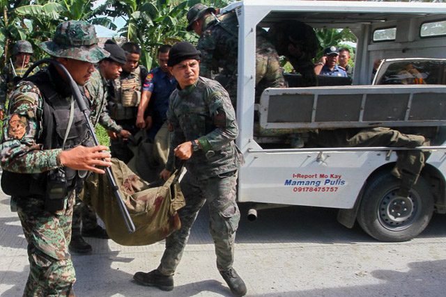BLUNDER. Police load the bodies of slain SAF members during the Mamasapano clash. File photo by Mark Navales/AFP 