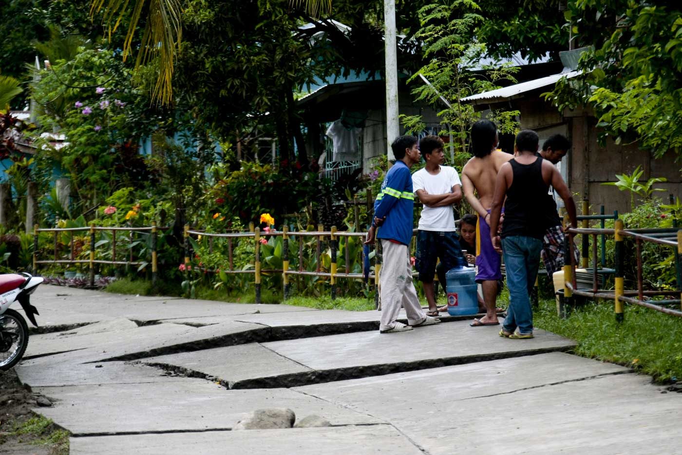 WAITING FOR REPAIRS. Residents gather on a road damaged by the quake. Photo by Gelo Litonjua  