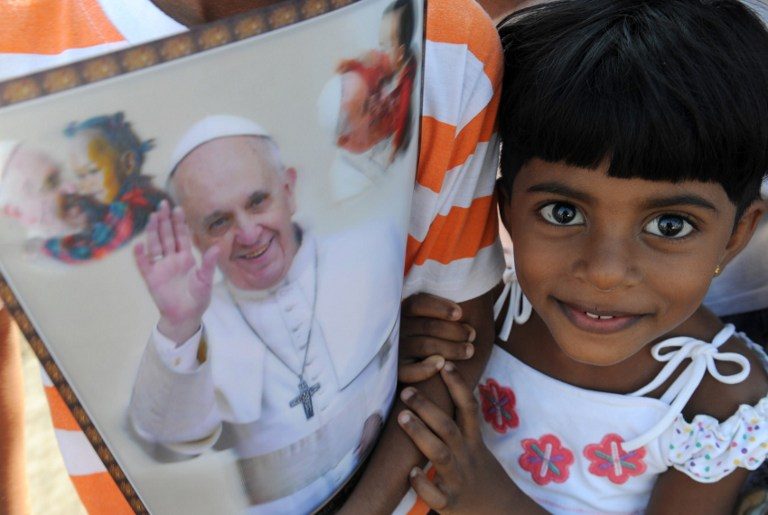 HUMAN RIGHTS. A young Sri Lankan holds paraphernalia bearing the portrait of Pope Francis as she waits for his arrival in Colombo on January 13, 2015. Pope Francis urged respect for human rights in Sri Lanka as he began a two-nation Asia tour on the island, bearing a message of peace and reconciliation after a long civil war. File photo by Lakruwan Wanniarachchi/AFP   