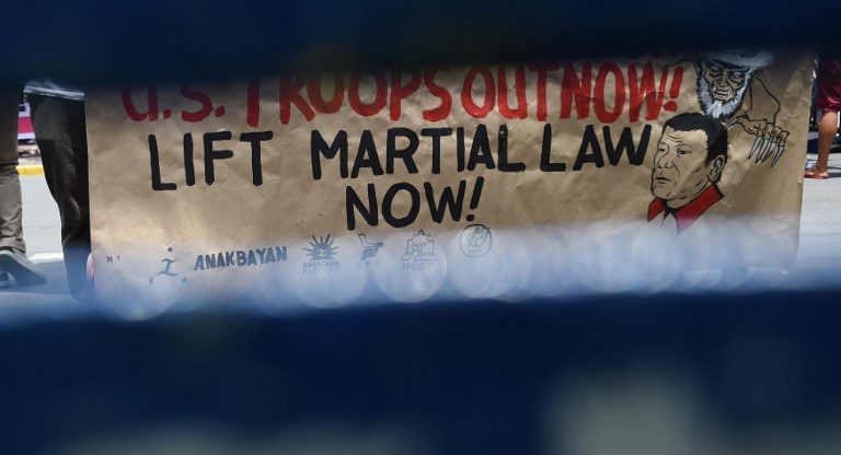 SC UPHOLDS DUTERTE'S MARTIAL LAW. An anti-martial law placard is seen past a policeman's shield during a rally in front of the Supreme Court in Manila on July 4, 2017. Photo by Ted Aljibe/AFP   
