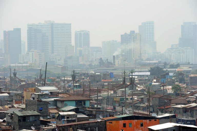 WHOSE CITY? This general view shows informal settlers' homes dwarfed by high-rise buildings near the port of Manila on August 20, 2014. File photo by Ted Aljibe/AFP 