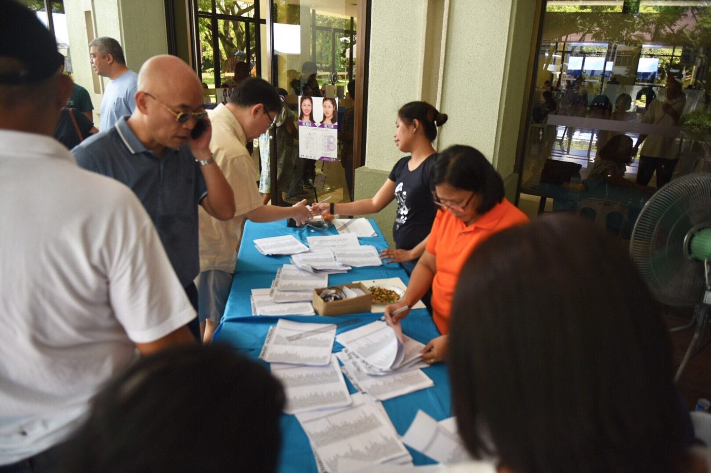 VOTERS' LIST. Volunteers help residents locate their name on the list of voters. Photo by Alecs Ongcal/Rappler 