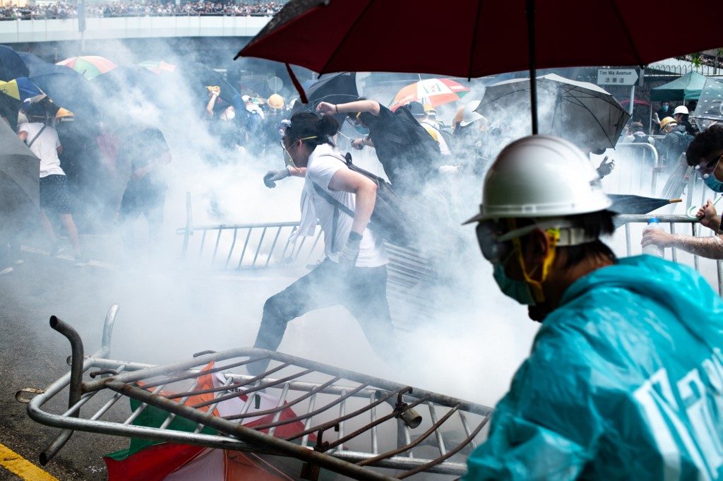 VIOLENCE. This file photo shows protesters running after police fired tear gas during a rally against a controversial extradition law proposal outside the government headquarters in Hong Kong on June 12, 2019. File photo by Philip Fong/AFP  