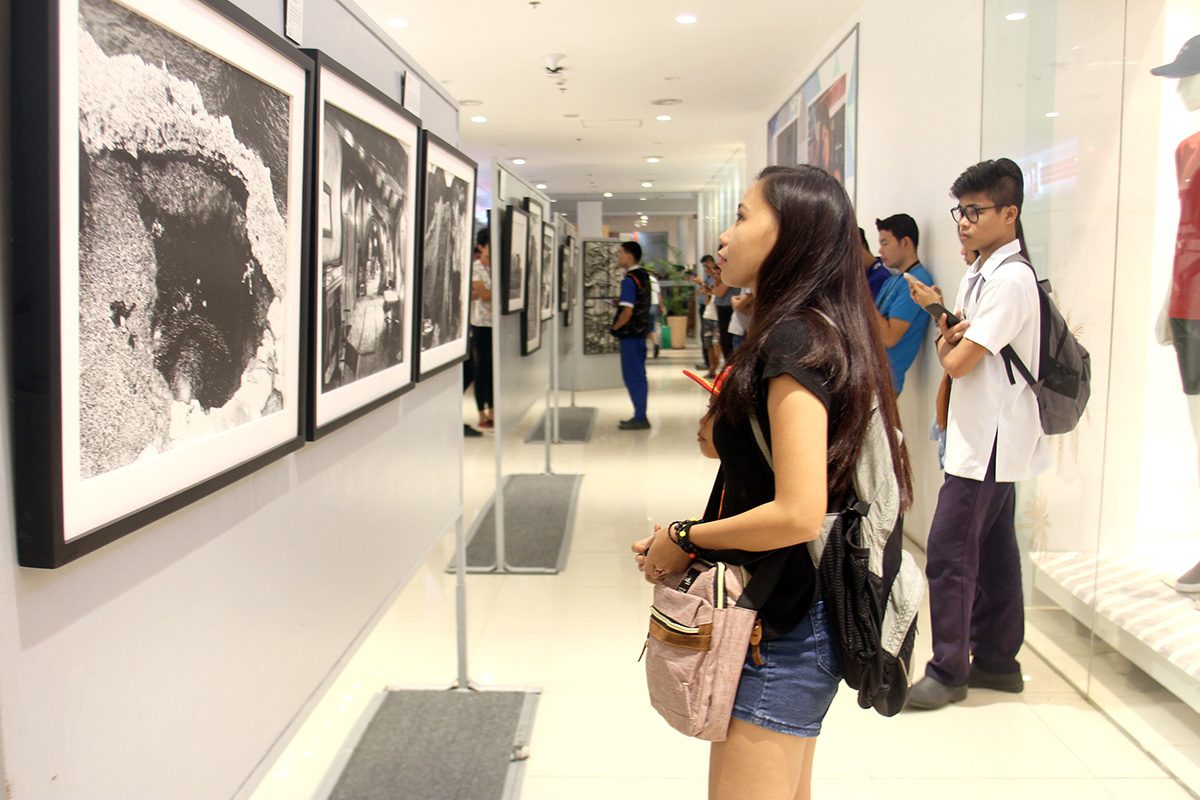 'A GREY JOURNEY'. Priest Vladimir Echalas sets up a photo exhibit from his travels the world as a missionary. Photo by Rhaydz B. Barcia/Rappler 