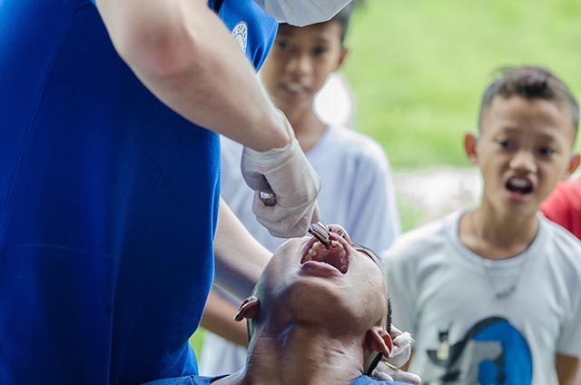 SAY 'AAH.' During Peña's visit, Makati city government representatives also provided medical and dental check-ups and services like free haircuts and film-viewing to the residents. Photo by Rob Reyes/Rappler 