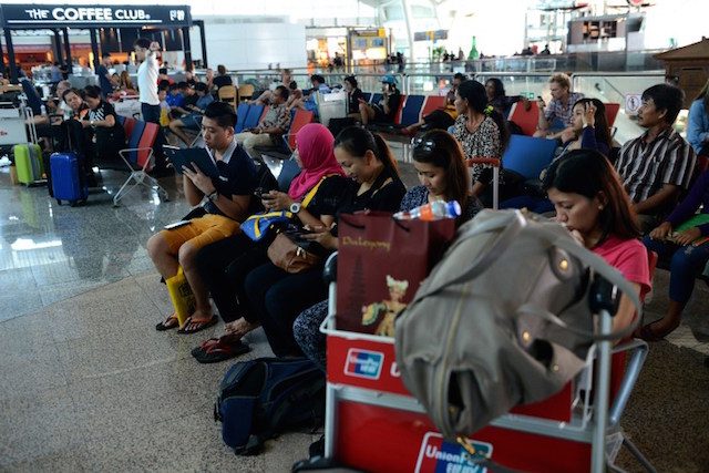 SLEEPLESS. Passengers wait for information on delayed and cancelled flights at the international departure area of Bali's Ngurah Rai Airport in Denpasar. AFP PHOTO / SONNY TUMBELAKA 