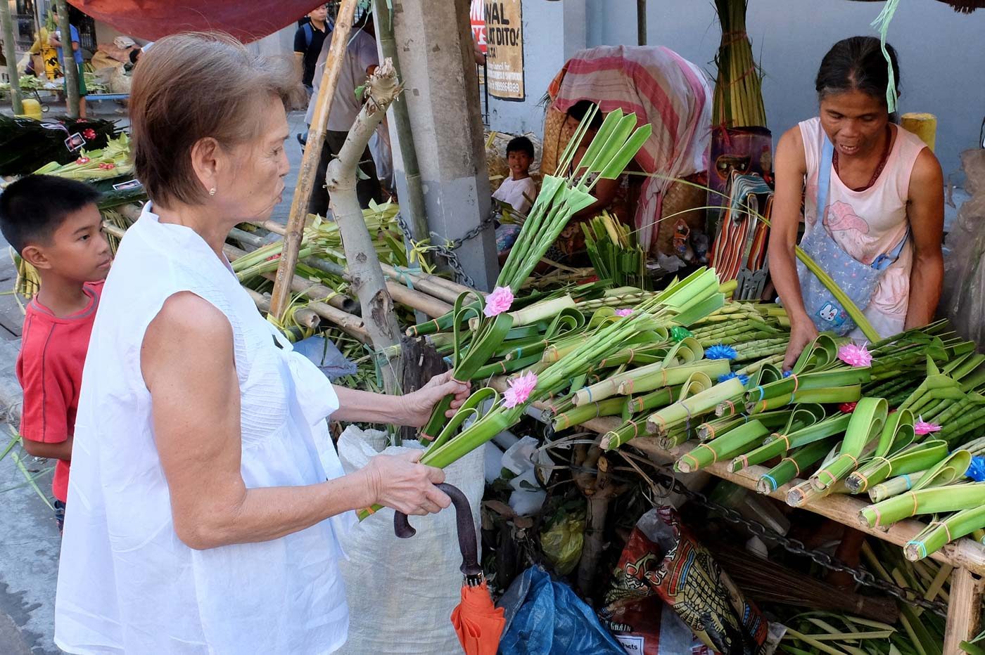 ADVANCE SALES. An elderly woman buys a palaspas in front of the Sto Domingo church in Quezon City on March 24, 2018, a day ahead of Palm Sunday. Photo by Angie de Silva/Rappler  