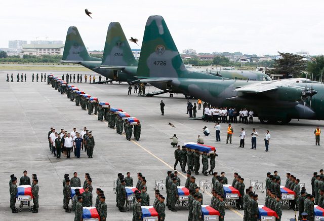 SOMBER ARRIVAL. Members of elite Police Special Action Force carry the remains of 42 of their 44 comrades from three C-130 planes  at Villamor Airbase, Pasay City on January 29, 2015. File photo by Dennis Sabangan/EPA   