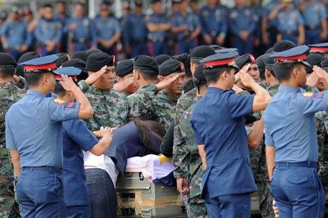 A relative mourns next to the flag-draped coffin of one of the slain SAF member during the arrival honors at the Villamor Airbase on January 29, 2015. Photo by Ted Aljibe/AFP  