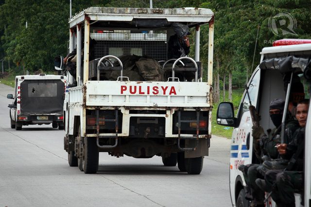 A police truck carrying the bodies of comrades passes the national highway during a retrieval operation on January 26, 2015 in Mamasapano, Maguindanao Province. The death toll of government fatalities in the fierce firefight reached fifty. 