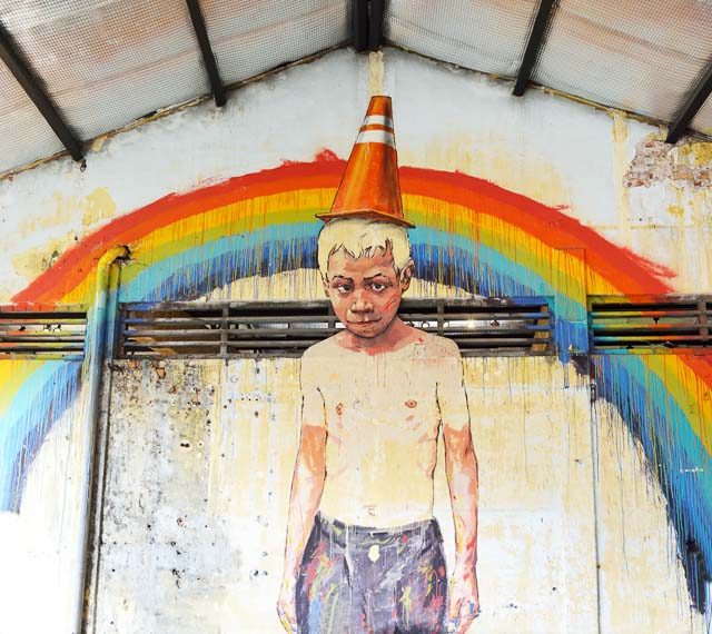 BOY ON THE WALL. Painted wall mural at Hinbus Depot Gallery by artist Ernest Zacharevic in George town, Penang, Malaysia. Photo by darkpurplebear/Shutterstock 