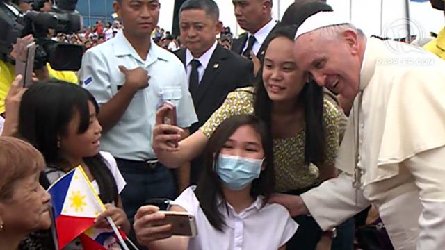 Two women take selfies with Pope Francis after his arrival from Tacloban at the Villamor Airbase in Manila, January 17, 2015.