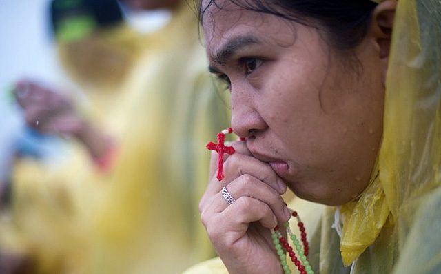 IN TEARS. A devotees prays during a mass led by Pope Francis at the DZR airport in Tacloban on January 17, 2015. Photo by Johannes Eiselle/AFP