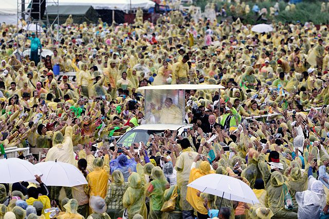 Pope Francis greets typhoon victims during a heavy downpour following a mass at the airport which was severely damaged by the 2013 Typhoon Yolanda/Haiyan in Tacloban City on January 17, 2015. Photo by Dennis Sabangan/EPA