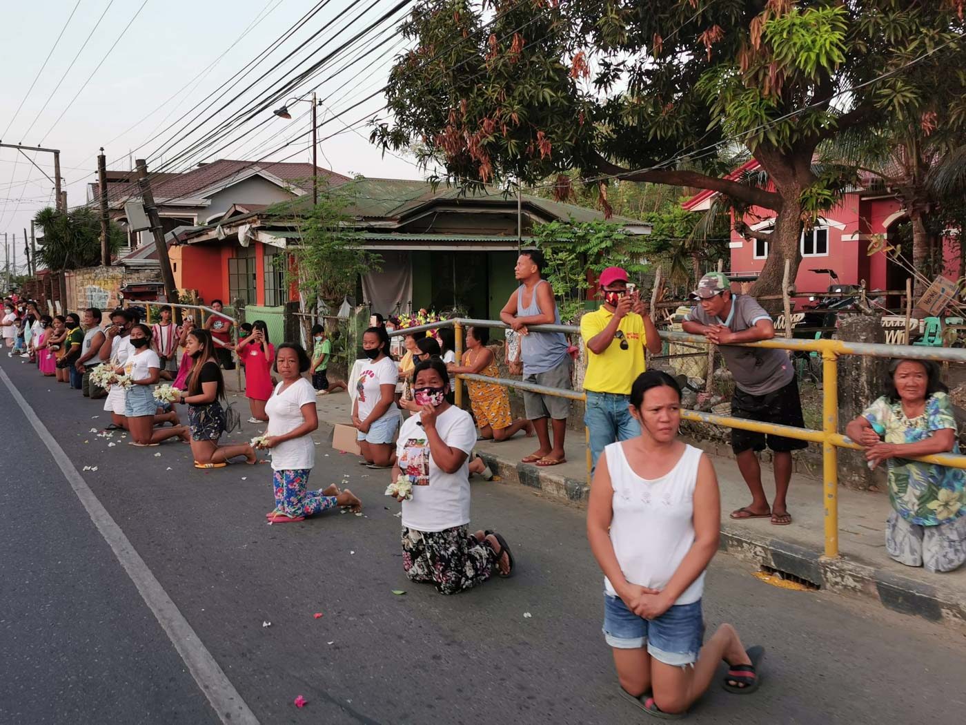 PRAYER. Residents of Ilocos Sur kneel along the highway as they wait for the convoy bearing the Señor Santo Cristo Milagroso de Sinait on Holy Wednesday, April 8. The faithful prayed for a miracle amid the coronavirus outbreak. Photo from PIO- Provincial Government of Ilocos Sur 