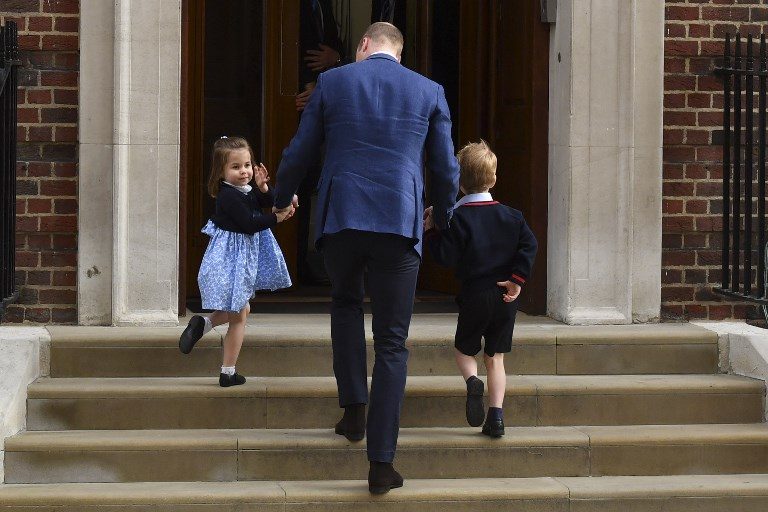 MEETING THEIR NEW BROTHER. Princess Charlotte of Cambridge (L) turns to wave at the media as she is lead in with her brother Prince George of Cambridge (R) by their father Britain's Prince William, Duke of Cambridge, (C) at the Lindo Wing of St Mary's Hospital in central London, on April 23, 2018, to visit Catherine, Duchess of Cambridge, and their new-born son. Photo by Ben Stansall/AFP  