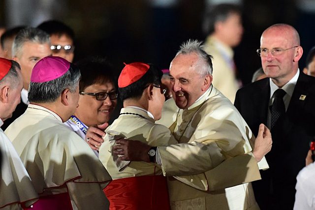 Pope Francis embraces Cardinal Luis Antonio Tagle after arriving at the Villamor Air Base on January 15, 2015. Photo by Giuseppe CacaceAFP