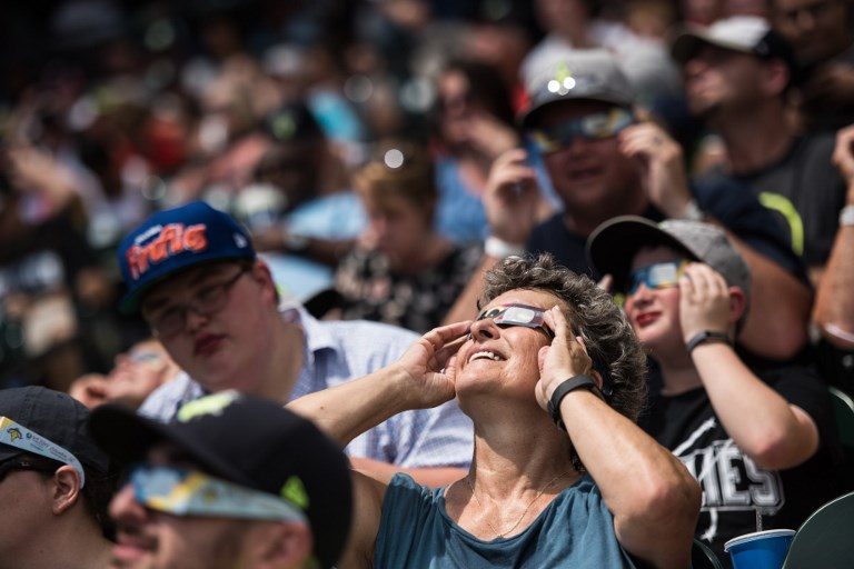 LOOKING UP. People watch a solar eclipse during a minor league baseball game at Spirit Communications Park August 21, 2017 in Columbia, South Carolina. Sean Rayford/Getty Images/AFP 