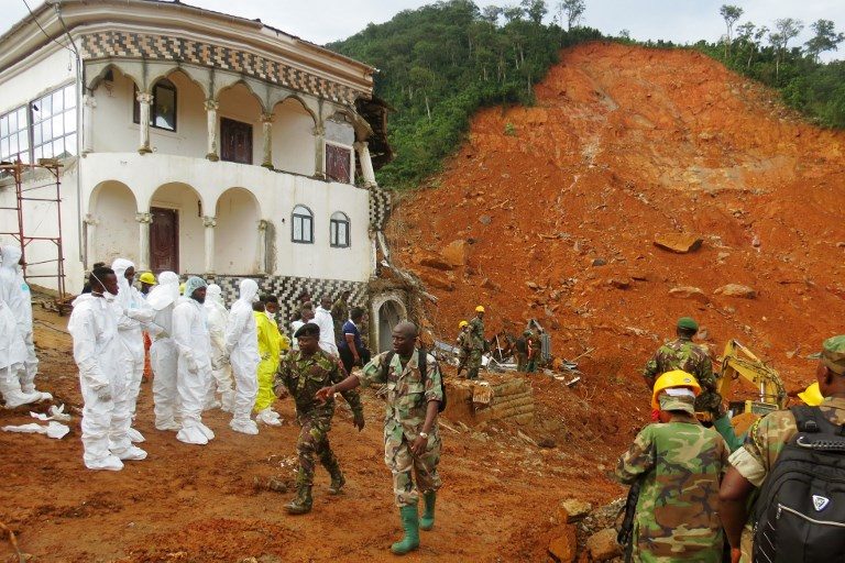 MUDSLIDE. Search and rescue team members and soldiers operate at a mudslide site and damaged building near Freetown on August 15, 2017, after landslides struck the capital of the west African state of Sierra Leone. Photo by Saidu Bah/AFP   