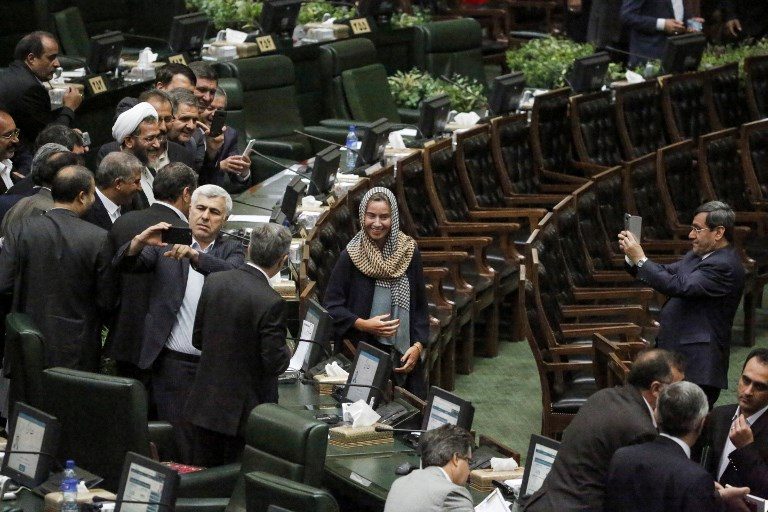 CENTER OF ATTENTION. Former Iranian foreign ministry spokesman Hassan Ghashghavi (R) uses a cellphone to take a picture of EU foreign policy chief Federica Mogherini (C) with Iranian MPs after the conclusion of the swearing in ceremony of the Iranian president before parliament in Tehran on August 5, 2017. Photo by Atta Kenare/AFP   