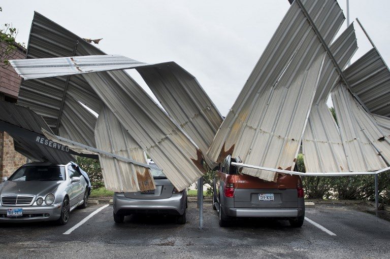 TWISTED. Cars are seen below a collapsed shelter following the passage of Hurricane Harvey on August 26, 2017 in Galveston, Texas. Photo by Brendan Smialowski/AFP  