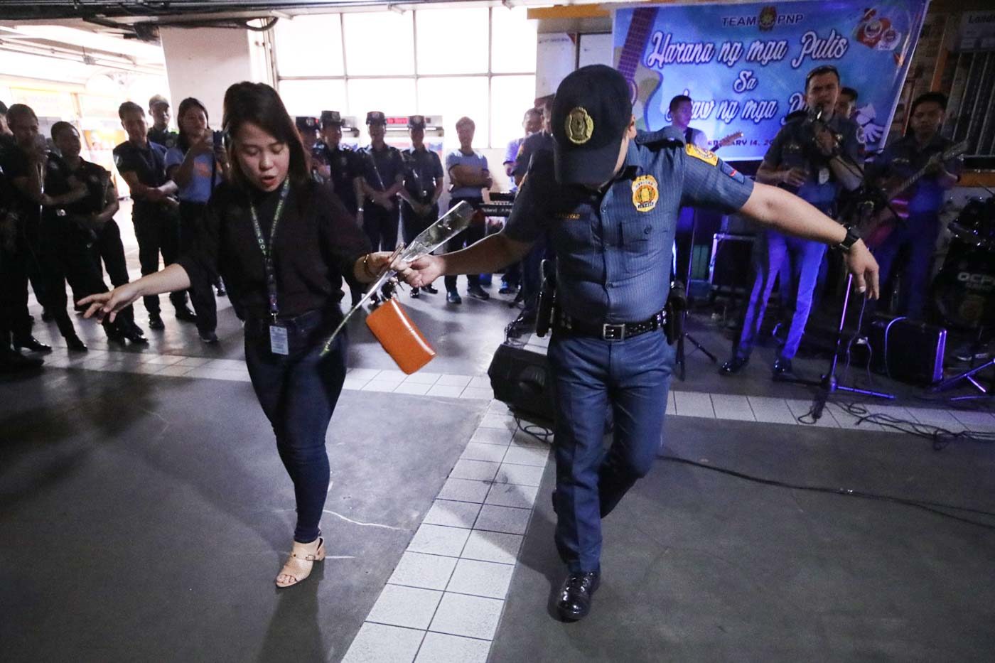 DANCE. A commuter busts a move with a cop who asked for a dance on Valentine's Day. Photo by Darren Langit/Rappler  