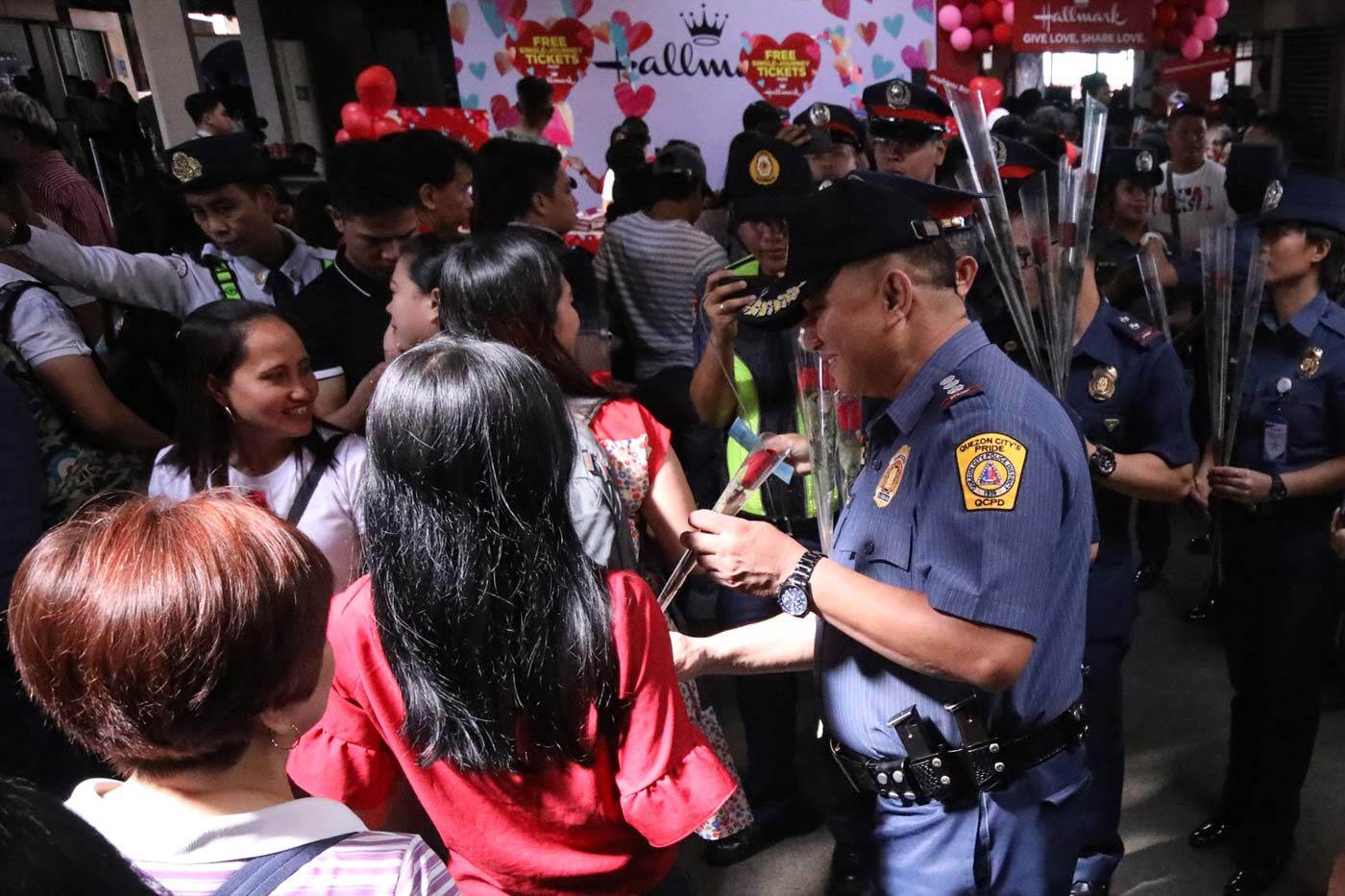 ROSES FOR ALL. Cops from the Quezon City Police District give away roses to commuters in Cubao. Photo by Darren Langit/Rappler  