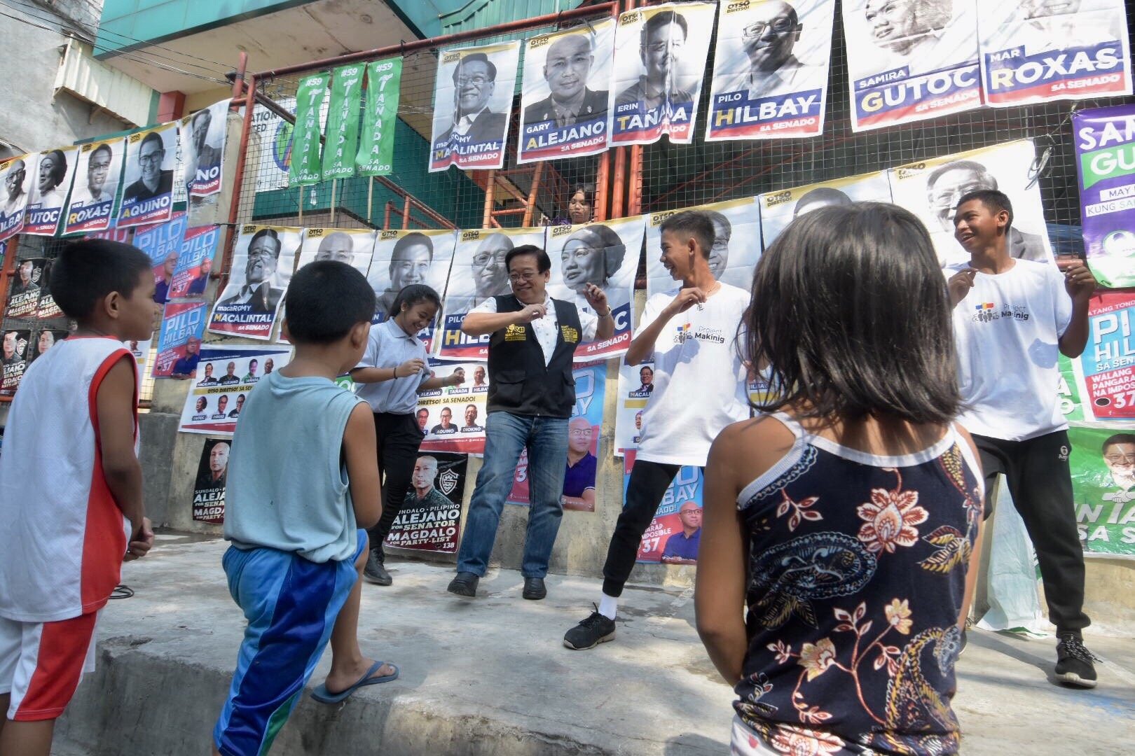 SIDEWALK CAMPAIGN. Otso Diretso candidate Romy Macalintal dances with some campaign volunteers on a sidewalk in Barangay Addition Hills, Mandaluyong City on March 12, 2019. Photo by Angie de Silva/Rappler 