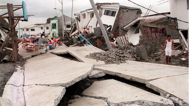 CHERRY HILLS. A man looks at a cracked road running past collapsed houses in the Cherry Hills residential subdivision of suburban Antipolo on August 4, 1999, following a landslide. File photo by Romeo Gacad/AFP 