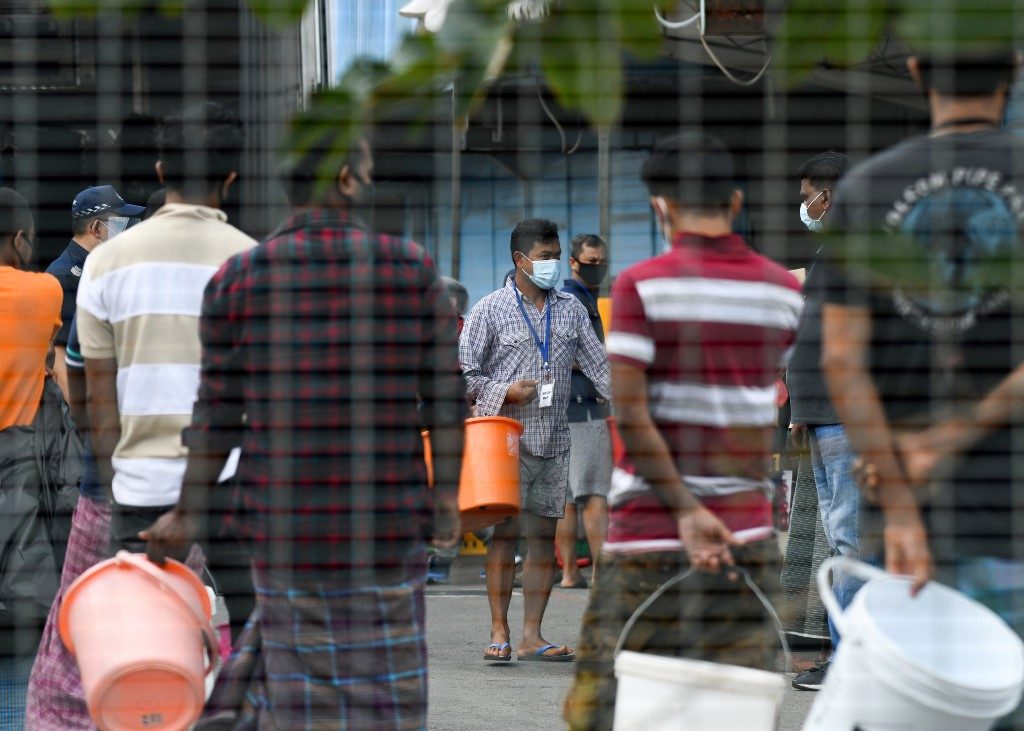 MIGRANT WORKERS. Residents queue for their food at Tuas South foreign workers' dormitory that has been placed under government restriction as preventive measure against the spread of the COVID-19 coronavirus in Singapore on April 19, 2020. Photo by Roslan Rahman/AFP 